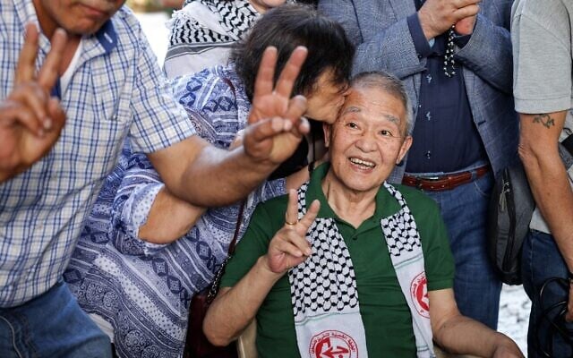 A woman kisses the head of Kozo Okamoto, the only surviving perpetrator of a 1972 massacre of 26 people in a terror attack carried out by members of the Japanese Red Army (JRA) at Israel's Lod airport, in Beirut on May 30, 2022. (JOSEPH EID / AFP) A woman kisses the head of Kozo Okamoto, the only surviving perpetrator of a 1972 massacre of 26 people in a terror attack carried out by members of the Japanese Red Army (JRA) at Israel's Lod airport, in Beirut on May 30, 2022. (JOSEPH EID / AFP)