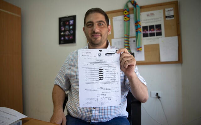 Palestinian American civil society activist Ubai Aboudi holds a copy of the Palestinian police report that includes the investigation and charges against him, at his office in the West Bank city of Ramallah, July 14, 2021. (AP Photo/Nasser Nasser, File) Palestinian American civil society activist Ubai Aboudi holds a copy of the Palestinian police report that includes the investigation and charges against him, at his office in the West Bank city of Ramallah, July 14, 2021. (AP Photo/Nasser Nasser, File)