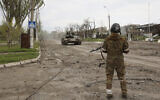 A serviceman of Donetsk People's Republic militia stands at a check point in Mariupol, in territory under the government of the Donetsk People's Republic, eastern Ukraine, Wednesday, May 4, 2022. (AP/Alexei Alexandrov)