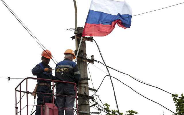 Municipal workers attach a Russian national flag to a pole preparing to celebrate 77 years of the victory in WWII in Mariupol, in territory under the government of the Donetsk People's Republic, eastern Ukraine, Thursday, May 5, 2022. (AP) Municipal workers attach a Russian national flag to a pole preparing to celebrate 77 years of the victory in WWII in Mariupol, in territory under the government of the Donetsk People's Republic, eastern Ukraine, Thursday, May 5, 2022. (AP)