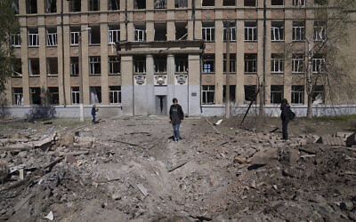A woman looks on a crater of an explosion after Russian airstrike in Kostyantynivka, Donetsk region, Ukraine, May 7, 2022. Evgeniy Maloletka/ AP)
