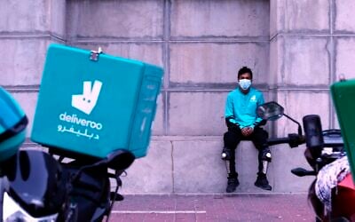 A food-delivery worker for Deliveroo takes a moment as he returns to work in Dubai, United Arab Emirates, May 2, 2022. (Isabel Debre/AP)