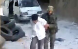Screen grab from the video showing a blindfolded Syrian man pushed by a Syrian agent before being shot dead and thrown into a large pit full of bodies in the Tadamon neighborhood of Damascus, Syria. (AP Photo)