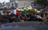 Palestinian mourners carry the body of Shireen Abu Akleh out of the office of Al Jazeera after friends and colleagues paid their respects, in the West Bank city of Ramallah, Wednesday, May 11, 2022. (AP/Nasser Nasser)