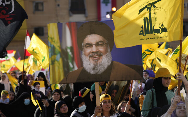 Hezbollah supporters wave portraits of Hezbollah leader Sayyed Hassan Nasrallah and their group flags, during an election campaign, in the southern suburb of Beirut, Lebanon, May 10, 2022. (AP Photo/Hussein Malla) Hezbollah supporters wave portraits of Hezbollah leader Sayyed Hassan Nasrallah and their group flags, during an election campaign, in the southern suburb of Beirut, Lebanon, May 10, 2022. (AP Photo/Hussein Malla)