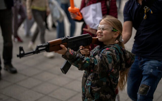 Victoria, 7, uses a plastic Kalashnikov rifle to shoot balls at a portrait of Russian President Vladimir Putin, at a street attraction in the center of Lviv, Ukraine, on May 14, 2022. (Emilio Morenatti/AP) Victoria, 7, uses a plastic Kalashnikov rifle to shoot balls at a portrait of Russian President Vladimir Putin, at a street attraction in the center of Lviv, Ukraine, on May 14, 2022. (Emilio Morenatti/AP)