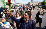 People march to the scene of a shooting at a supermarket in Buffalo, N.Y., Sunday, May 15, 2022. (AP Photo/Matt Rourke)