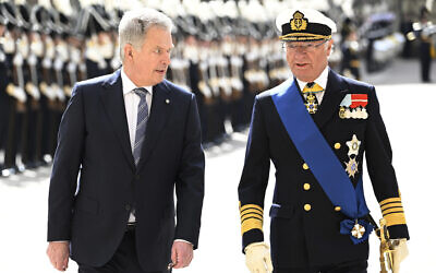 Finland's President Sauli Niinistö, left, and Sweden's King Carl Gustaf walk in the  Royal Courtyard in Stockholm, May 17, 2022. (Anders Wiklund/TT News Agency via AP)