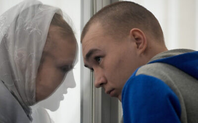 Russian Sgt. Vadim Shishimarin listens to his translator during a court hearing in Kyiv, Ukraine, May 23, 2022. (AP Photo/Natacha Pisarenko)