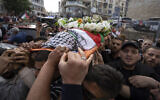Palestinian mourners carry the body of veteran Palestinian-American reporter Shireen Abu Akleh out of the office of Al Jazeera after friends and colleagues paid their respects, in the West Bank city of Ramallah, May 11, 2022. (AP/Nasser Nasser, File)