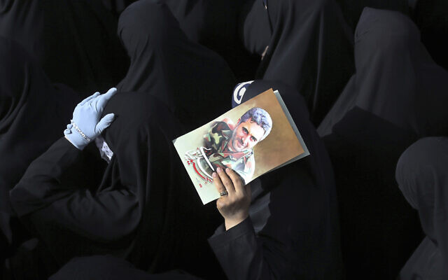 Mourners attend the funeral ceremony of Iran's Revolutionary Guard Col. Hassan Sayyad Khodaei, shown in the poster, who was killed on Sunday, in Tehran, Iran, May 24, 2022.  (Vahid Salemi/AP)