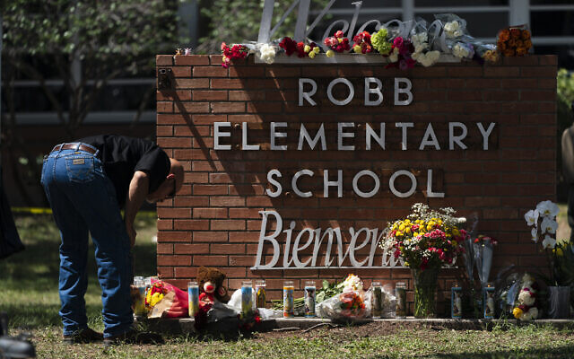 A law enforcement officer lights a candle outside Robb Elementary School in Uvalde, Texas, Wednesday, May 25, 2022. (AP/Jae C. Hong) A law enforcement officer lights a candle outside Robb Elementary School in Uvalde, Texas, Wednesday, May 25, 2022. (AP/Jae C. Hong)