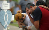 Vincent Salazar, right, father of Layla Salazar, weeps while kneeling in front of a cross with his daughter's name at a memorial site for the victims killed in this week's elementary school shooting in Uvalde, Texas, May 27, 2022. (AP Photo/Dario Lopez-Mills)