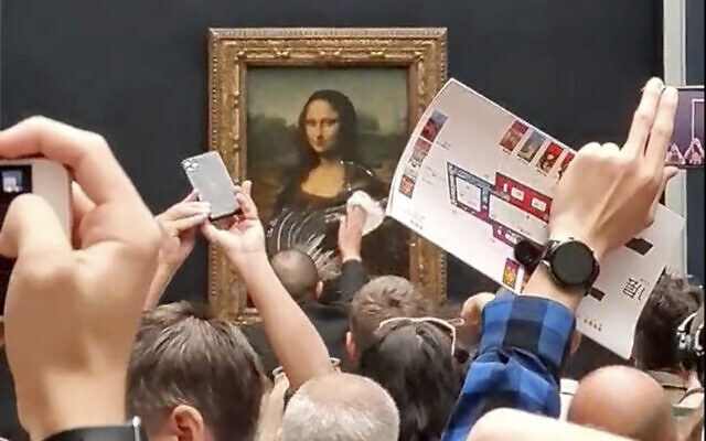 A security guard cleans smeared cream from the glass protecting the Mona Lisa at the Louvre Museum, in Paris, France, May 29, 2022. (@Klevisl007 via AP) A security guard cleans smeared cream from the glass protecting the Mona Lisa at the Louvre Museum, in Paris, France, May 29, 2022. (@Klevisl007 via AP)