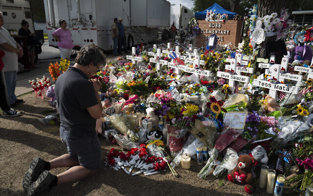 Salvatore Di Grazia, a teacher visiting from Rio Grande Valley, Texas, prays at a memorial at Robb Elementary School in Uvalde, Texas Monday, May 30, 2022, for the victims killed in last week's school shooting. (AP Photo/Jae C. Hong) Salvatore Di Grazia, a teacher visiting from Rio Grande Valley, Texas, prays at a memorial at Robb Elementary School in Uvalde, Texas Monday, May 30, 2022, for the victims killed in last week's school shooting. (AP Photo/Jae C. Hong)