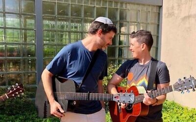 Rabbi Daniel Bogard (left) and Shira Berkowitz (right) lead songs at Camp Ramot Amoona. (Courtesy Shira Berkowitz via JTA)