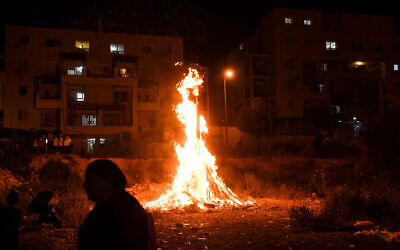 People celebrate Lag B'Omer near a bonfire, in Kiryat Sefer on May 22, 2019. (Yossi Zeliger/Flash90)