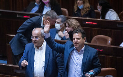 Ahmad Tibi, left, and Ayman Odeh of the Arab Joint List during a plenum session in the assembly hall of the Israeli parliament, in Jerusalem, on July 6, 2021. (Yonatan Sindel/Flash90)