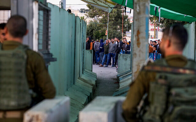 Israeli security forces guard as Palestinians make their way through a checkpoint to attend Friday prayers at Jerusalem's Temple Mount, near the West Bank city of Bethlehem, April 22, 2022. (Wisam Hashlamoun/Flash90_ Israeli security forces guard as Palestinians make their way through a checkpoint to attend Friday prayers at Jerusalem's Temple Mount, near the West Bank city of Bethlehem, April 22, 2022. (Wisam Hashlamoun/Flash90_