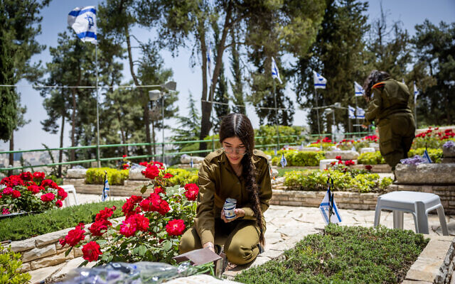 Israeli soldiers put flowers and candles on graves of fallen soldiers in Mount Herzl Military Cemetery in Jerusalem, on May 3, 2022, ahead of Israeli Memorial Day, May 4, 2022. (Yonatan Sindel/Flash90) Israeli soldiers put flowers and candles on graves of fallen soldiers in Mount Herzl Military Cemetery in Jerusalem, on May 3, 2022, ahead of Israeli Memorial Day, May 4, 2022. (Yonatan Sindel/Flash90)