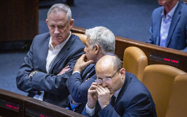 Then-Defense Minister Benny Gantz, left, then-Foreign Minister Yair Lapid, center, and then-Prime Minister Naftali Bennett attend a plenum session in the assembly hall of the Knesset, on May 16, 2022. (Olivier Fitoussi/FLASH90) Then-Defense Minister Benny Gantz, left, then-Foreign Minister Yair Lapid, center, and then-Prime Minister Naftali Bennett attend a plenum session in the assembly hall of the Knesset, on May 16, 2022. (Olivier Fitoussi/FLASH90)