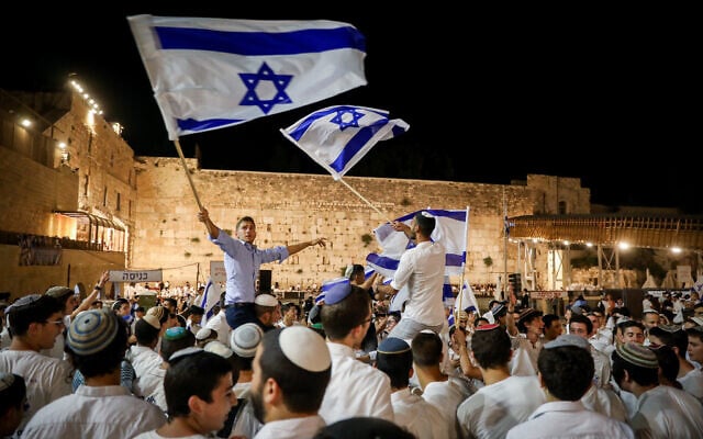 Jewish men dance with Israeli flags at the Western Wall in Jerusalem Old City on the eve of Jerusalem Day, May 28, 2022. (Noam Revkin Fenton/Flash90) Jewish men dance with Israeli flags at the Western Wall in Jerusalem Old City on the eve of Jerusalem Day, May 28, 2022. (Noam Revkin Fenton/Flash90)
