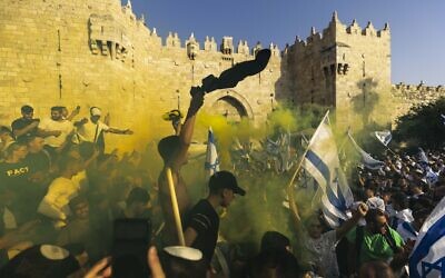 Young Jewish men holding Israeli flags as they dance at Damascus Gate in Jerusalem's Old City, during Jerusalem Day celebrations, May 29, 2022. (Olivier Fitoussi/Flash90)