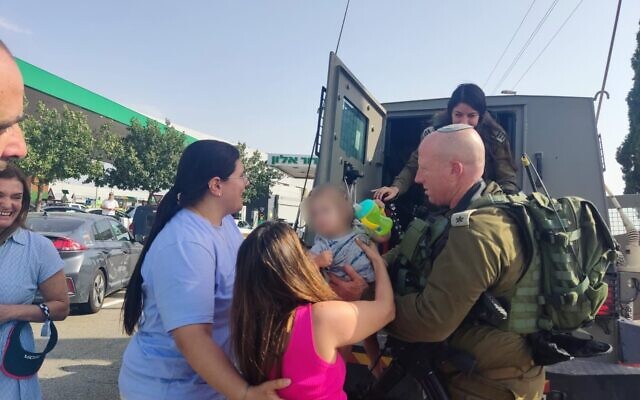 Col. Arik Moyal and other IDF soldiers return a toddler to his mother, after the car he was in was stolen from a gas station in northern Israel and taken to a West Bank town on May 28, 2022. (Israel Defense Forces) Col. Arik Moyal and other IDF soldiers return a toddler to his mother, after the car he was in was stolen from a gas station in northern Israel and taken to a West Bank town on May 28, 2022. (Israel Defense Forces)