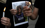 Protesters hold candles and a photo of Al Jazeera journalist Shireen Abu Akleh, who was killed while covering clashes between IDF troops and Palestinian gunmen during an IDF raid in Jenin, in Haifa on May 11, 2022. (AP Photo/Ariel Schalit)