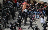 Israeli police confront mourners as they carry the casket of Al Jazeera journalist Shireen Abu Akleh, almost toppling it, outside Saint Joseph's Hospital during her funeral in Jerusalem, May 13, 2022. (AP Photo/Maya Levin)