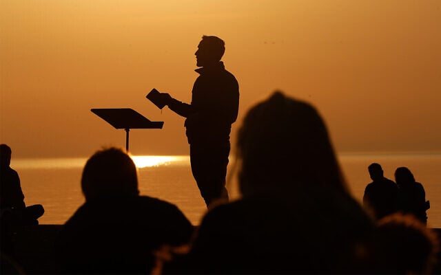 Park Community Church Associate Pastor Trevor Lovell is silhouetted against the sky as he leads an Easter sunrise service while parishioners listen on Sunday, April 4, 2021, at North Avenue Beach in Chicago. (AP Photo/Shafkat Anowar, File) Park Community Church Associate Pastor Trevor Lovell is silhouetted against the sky as he leads an Easter sunrise service while parishioners listen on Sunday, April 4, 2021, at North Avenue Beach in Chicago. (AP Photo/Shafkat Anowar, File)