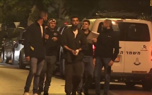 Subhi Emad Sbeihat (cuffed, center) walks through Elad with investigators to reenact the deadly terror attack, May 9, 2022 (screenshot: Channel 13) Subhi Emad Sbeihat (cuffed, center) walks through Elad with investigators to reenact the deadly terror attack, May 9, 2022 (screenshot: Channel 13)