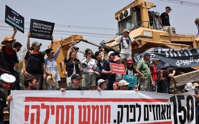 Peace Now activists ahead of planned protest at the illegal Homesh outpost in the West Bank, May 28, 2022. The banner at front reads: "150 outposts to dismantle. Homesh first!" (Peace Now) Peace Now activists ahead of planned protest at the illegal Homesh outpost in the West Bank, May 28, 2022. The banner at front reads: "150 outposts to dismantle. Homesh first!" (Peace Now)