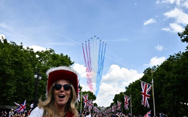 Members of the public cheer as they watch the Royal Air Force Aerobatic Team, the Red Arrows, during the Queen's Birthday Parade, the Trooping the Color, as part of Queen Elizabeth II's Platinum Jubilee celebrations, in London on June 2, 2022. (Ben Stansall/AFP)