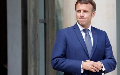 France's President Emmanuel Macron waits for his Senegalese counterpart on the doorsteps of the at the Elysee presidential palace before their meeting in Paris on June 10, 2022. (Ludovic Marin/AFP)