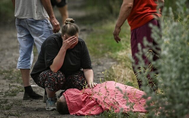 A woman mourns over the body of her relative who was reportedly killed by a cluster rocket in the city of Lysychansk in the eastern Ukrainian region of Donbas on June 18, 2022 amid the Russian invasion of the country. (ARIS MESSINIS / AFP) A woman mourns over the body of her relative who was reportedly killed by a cluster rocket in the city of Lysychansk in the eastern Ukrainian region of Donbas on June 18, 2022 amid the Russian invasion of the country. (ARIS MESSINIS / AFP)