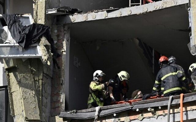 EDITORS NOTE: Graphic content / Rescuers evacuate a person from a damaged residential building hit by Russian missiles in Kyiv on June 26, 2022, amid Russian invasion of Ukraine. -(Genya SAVILOV / AFP)