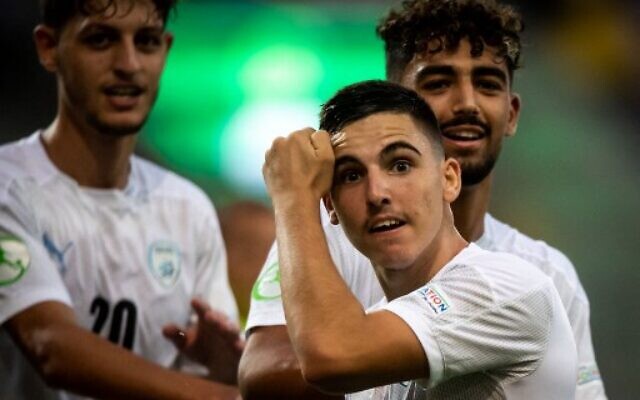 Israel's midfielder Oscar Gloukh celebrates scoring the opening goal with his teammates during the UEFA Under-19 European Championship semi-final football match between France and Israel at the DAC Arena in Dunajska Streda, Slovakia on June 28, 2022. (VLADIMIR SIMICEK / AFP)