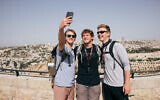 Christian tourists in Israel through the 'Passages' program pose for a selfie on Jerusalem's Haas Promenade overlooking the capital's Old City, in an undated photograph. (Mattanah DeWitt/Passages)