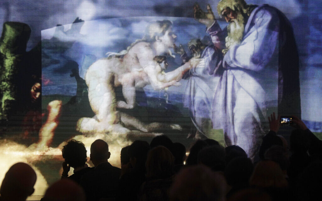 Journalists admire a footage displaying a segment of the show 'Giudizio Universale' (Last Judgement), Michelangelo and the Secrets of the Sistine Chapel, at the Auditorium Conciliazione, in Rome, Monday, March 12, 2018. (AP Photo/Gregorio Borgia)