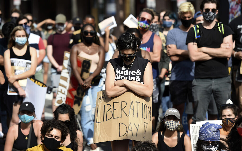 An attendee takes part in a moment of silence at a Juneteenth forum, June 19, 2020, outside the Laugh Factory comedy club in Los Angeles. (AP Photo/Chris Pizzello)