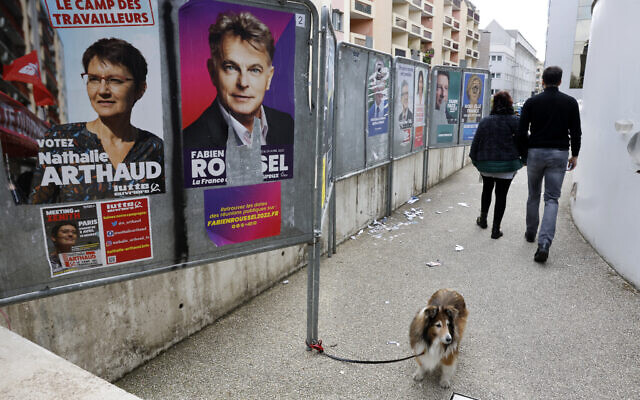 Illustrative: A dog walks past presidential campaign posters during the first round of the French presidential election, in Strasbourg, eastern France, April 10, 2022. (AP Photo/Jean-Francois Badias) Illustrative: A dog walks past presidential campaign posters during the first round of the French presidential election, in Strasbourg, eastern France, April 10, 2022. (AP Photo/Jean-Francois Badias)