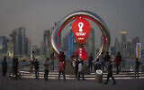 People gather around the official countdown clock showing remaining time until the kick-off of the World Cup 2022, in Doha, Qatar, November 25, 2021. (AP/Darko Bandic)