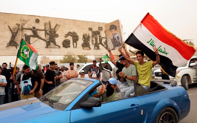 Followers of Shiite cleric Muqtada al-Sadr hold a poster with his photo and wave an Iraqi flag as they celebrate the passing of a law criminalizing the normalization of ties with Israel, in Tahrir Square, Baghdad, Iraq, May 26, 2022. (AP Photo/Hadi Mizban) Followers of Shiite cleric Muqtada al-Sadr hold a poster with his photo and wave an Iraqi flag as they celebrate the passing of a law criminalizing the normalization of ties with Israel, in Tahrir Square, Baghdad, Iraq, May 26, 2022. (AP Photo/Hadi Mizban)