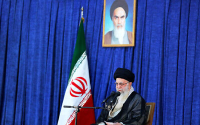 Supreme Leader Ayatollah Ali Khamenei speaks on the anniversary of the death of the late founder of the Islamic Republic, Ayatollah Ruhollah Khomeini, shown in the poster at top center, at his mausoleum in Tehran, Iran, June 4, 2022. (Office of the Iranian Supreme Leader via AP)