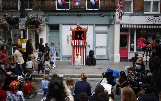 A young girl looks up at a Punch and Judy show during a public street party in Elizabeth Street in central London, June 5, 2022, on the last of four days of celebrations to mark the Platinum Jubilee. (AP Photo/David Cliff) A young girl looks up at a Punch and Judy show during a public street party in Elizabeth Street in central London, June 5, 2022, on the last of four days of celebrations to mark the Platinum Jubilee. (AP Photo/David Cliff)