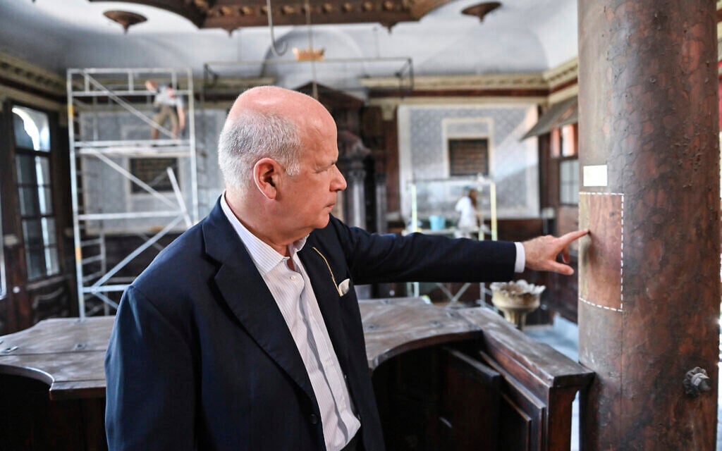 Art historian David Landau points out a restored area of a wooden column in the 1575 Italian Schola Synagogue in Venice, northern Italy, June 1, 2022. Landau is spearheading the fundraising effort to restore Venice's synagogues and nearby buildings both for Venice’s small Jewish community and for tourists who can visit them on a guided tour through the Jewish Museum of Venice. (AP Photo/Chris Warde-Jones)