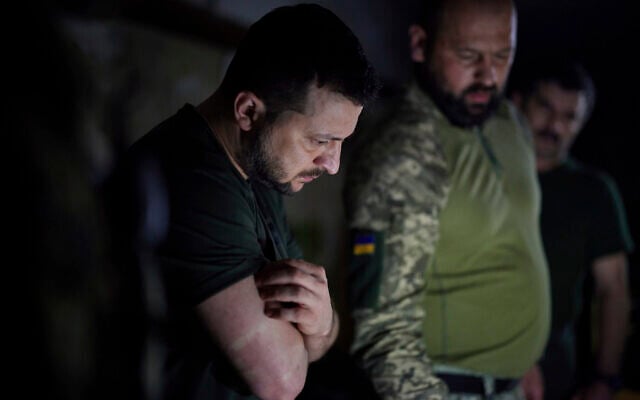 In this photo provided by the Ukrainian Presidential Press Office, Ukrainian President Volodymyr Zelensky, left, listens to a servicemen report close to the front line in Donetsk region, Ukraine, June 5, 2022. (Ukrainian Presidential Press Office via AP)
