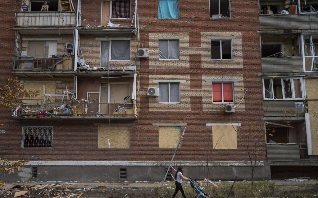 A woman pushes a baby stroller near a building damaged during a Russian attack in Slovyansk, eastern Ukraine, June 4, 2022. (Bernat Armangue/AP)