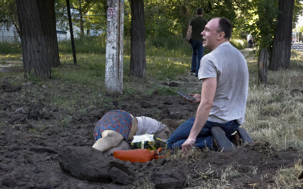 A man cries over the body of his girlfriend killed by shelling in the Kalininsky district of Donetsk, on the territory which is under the Government of the Donetsk People's Republic control, eastern Ukraine, June 9, 2022. (AAlexei Alexandrov/AP)